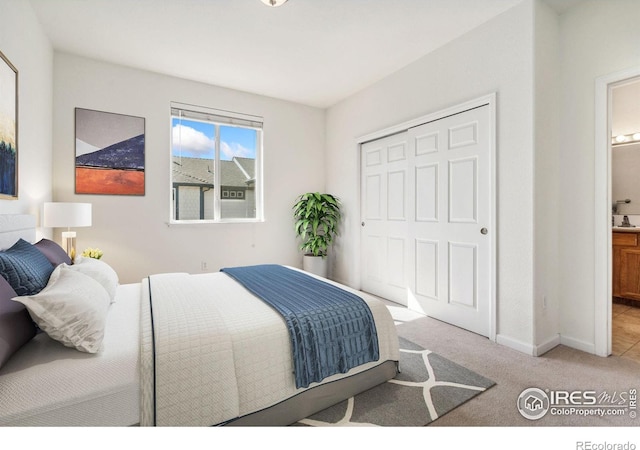 bedroom featuring light colored carpet, ensuite bathroom, and a closet