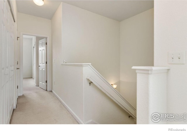 hallway featuring light colored carpet