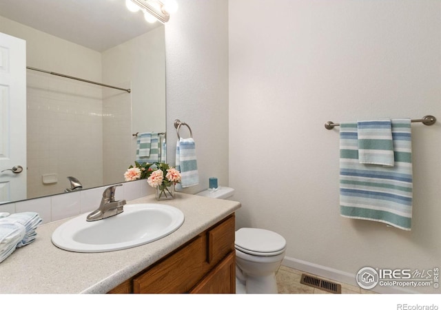 bathroom featuring walk in shower, vanity, toilet, and tile patterned floors