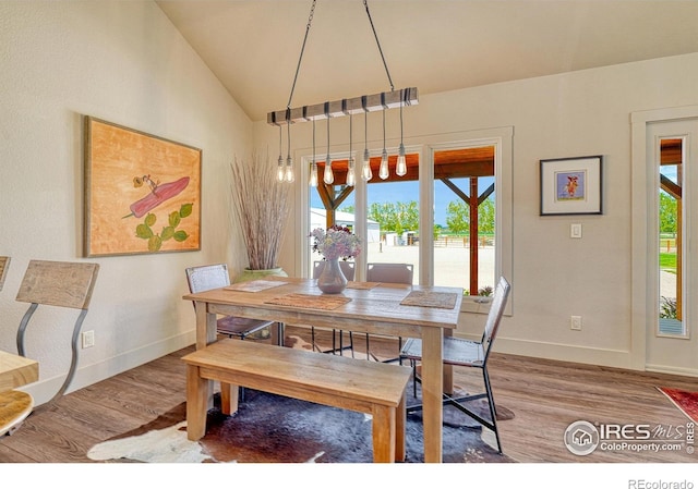 dining space with wood-type flooring and lofted ceiling