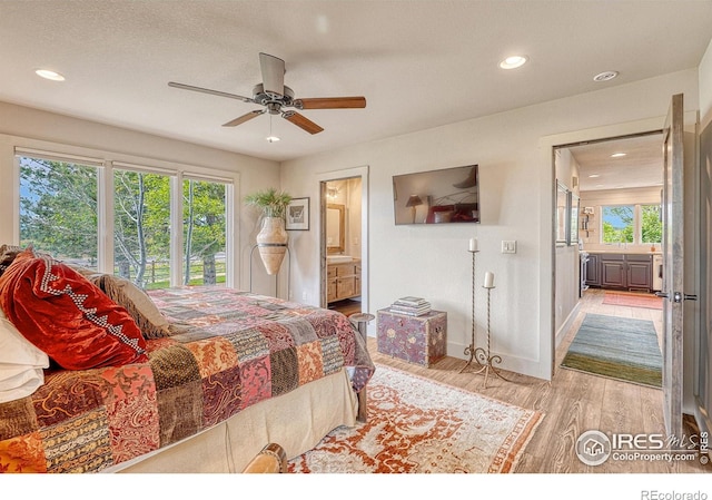 bedroom featuring ceiling fan, ensuite bath, and hardwood / wood-style floors