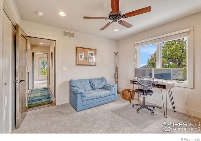 office space with ceiling fan, light carpet, and plenty of natural light