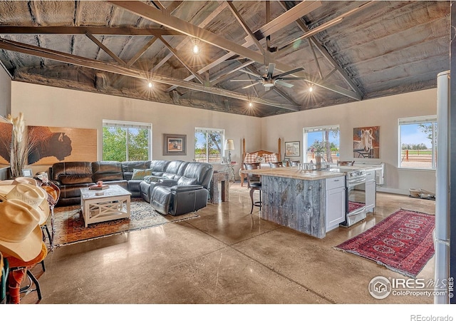 living room with high vaulted ceiling, ceiling fan, and beamed ceiling