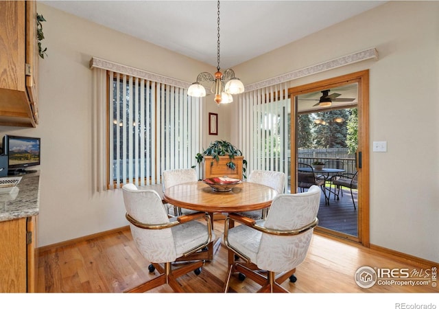 dining area with ceiling fan with notable chandelier and light wood-type flooring