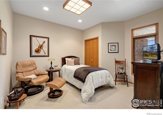 bedroom with light carpet and a closet