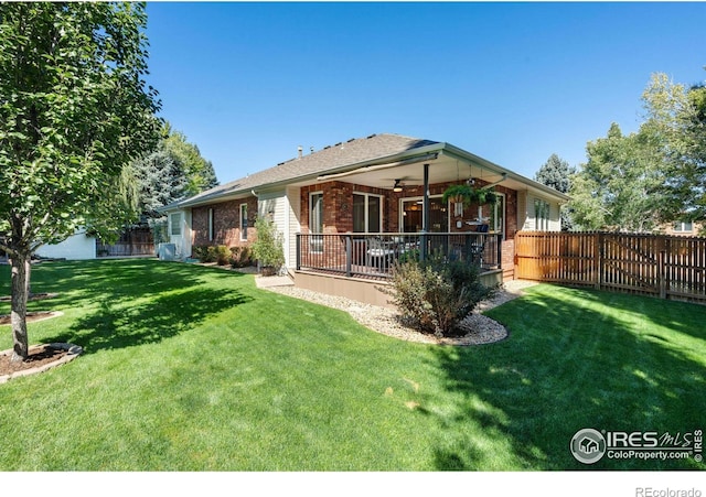 back of property with a lawn and ceiling fan