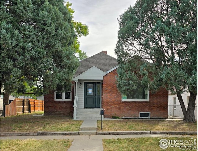 bungalow-style home with brick siding and a shingled roof