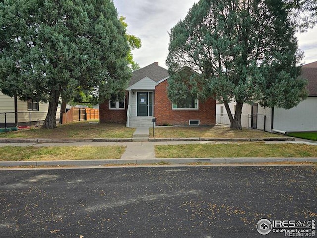 view of front facade with fence and brick siding