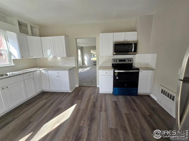 kitchen with stainless steel appliances, white cabinetry, and dark wood-style flooring