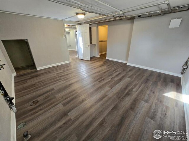 basement featuring dark wood finished floors and baseboards