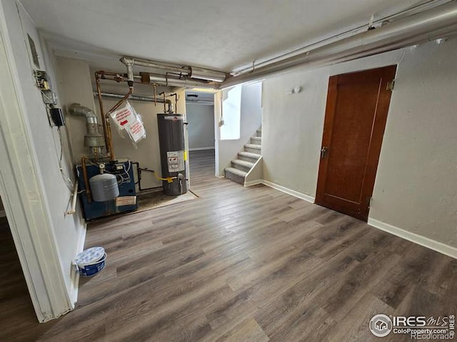 basement featuring gas water heater, stairway, wood finished floors, and baseboards