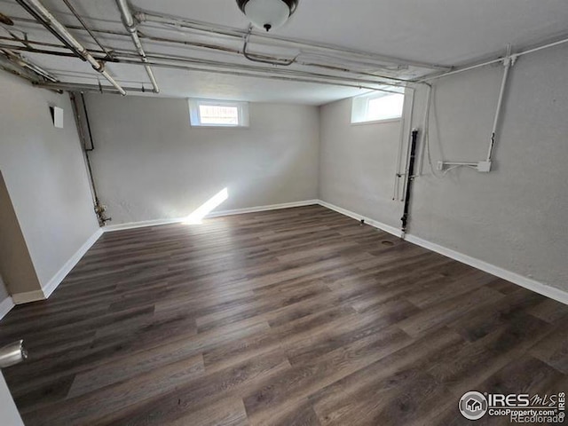 basement with baseboards and wood finished floors
