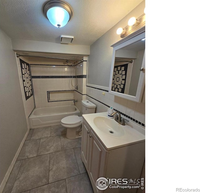 bathroom with toilet, vanity, shower / bathtub combination, a textured ceiling, and tile patterned floors