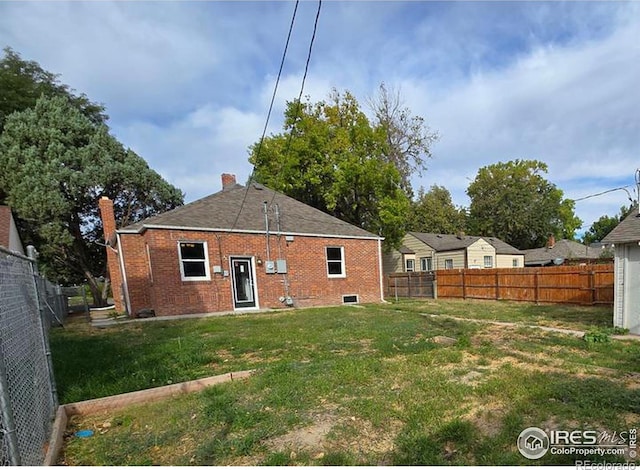 back of property with brick siding and a chimney