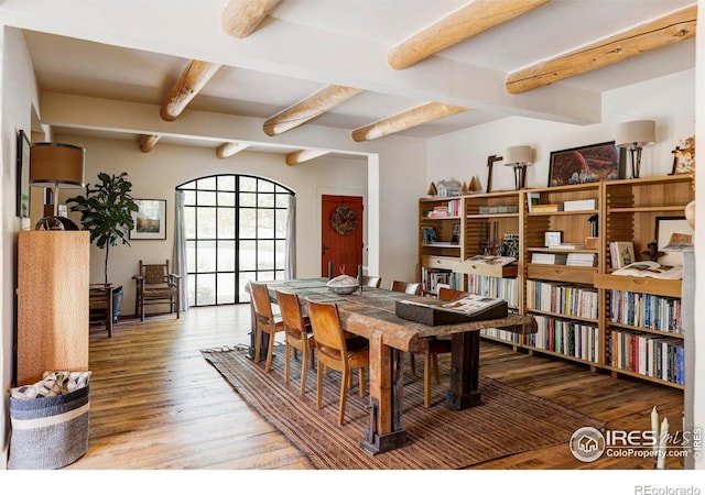 dining area featuring wood-type flooring and beam ceiling