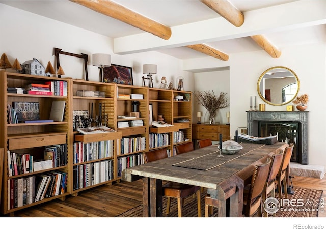 dining space featuring beam ceiling and dark hardwood / wood-style flooring