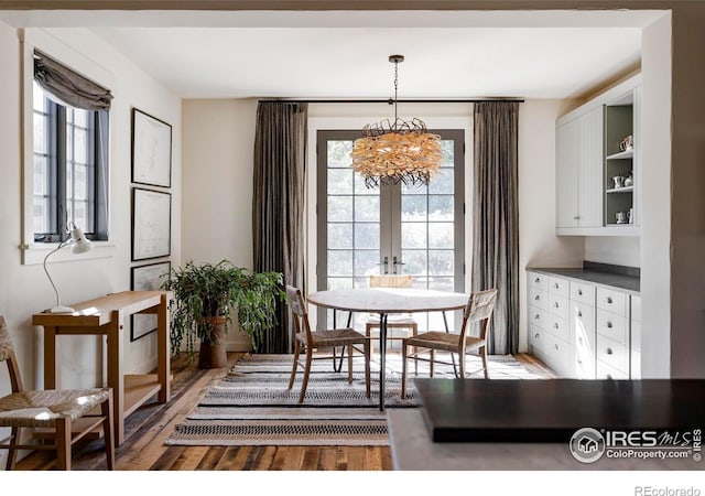 dining space featuring a wealth of natural light, an inviting chandelier, and hardwood / wood-style flooring