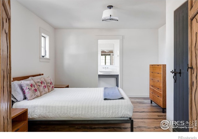 bedroom featuring multiple windows, dark hardwood / wood-style floors, and ensuite bathroom