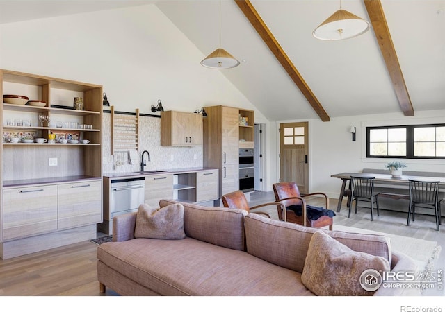 living room with high vaulted ceiling, light hardwood / wood-style floors, beamed ceiling, and sink