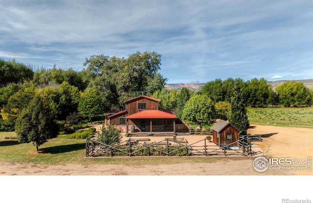 rear view of house featuring a rural view