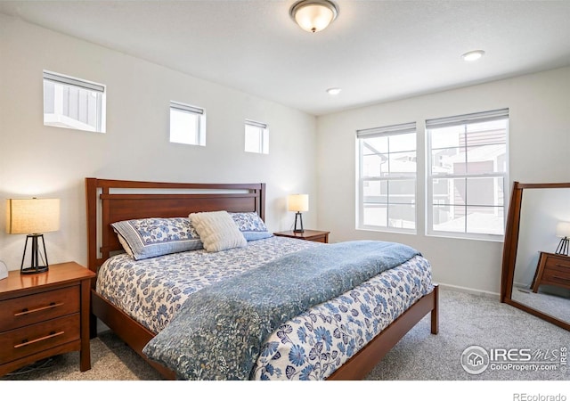 bedroom featuring light colored carpet and multiple windows