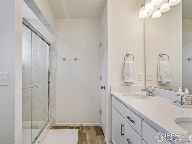 bathroom with vanity, hardwood / wood-style floors, and a shower with shower door