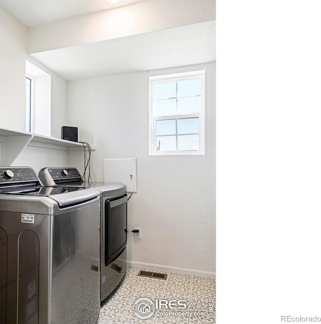 laundry area with washing machine and dryer and light tile patterned flooring