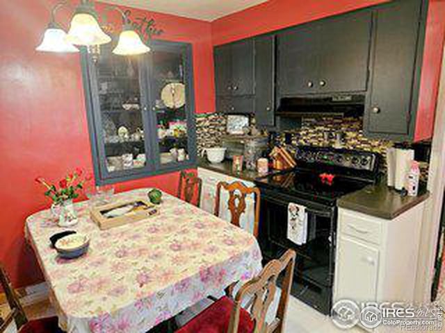 kitchen featuring decorative backsplash, black / electric stove, and decorative light fixtures