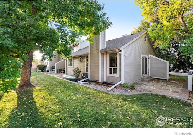 rear view of house featuring cooling unit, a patio, and a lawn