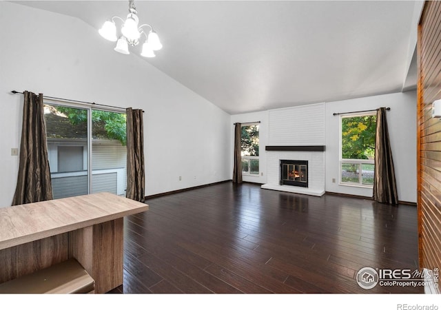 unfurnished living room featuring lofted ceiling, a chandelier, a fireplace, and dark hardwood / wood-style flooring