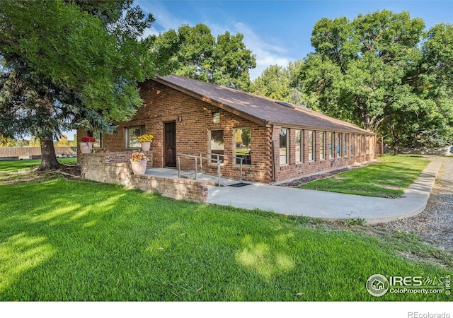 exterior space with a front yard and a patio area