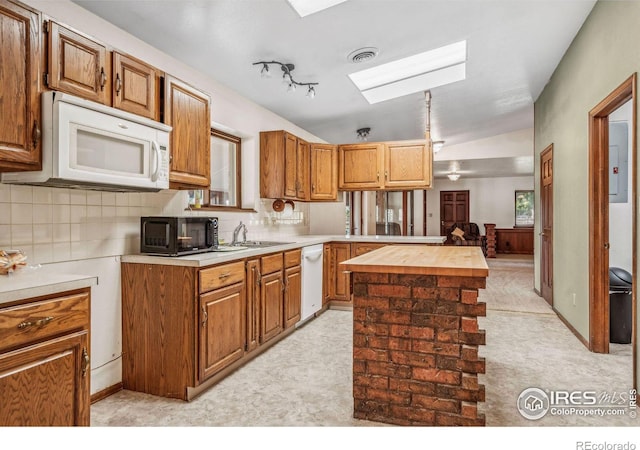 kitchen featuring lofted ceiling, sink, white appliances, decorative backsplash, and butcher block counters