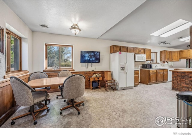 carpeted dining area featuring a textured ceiling and sink