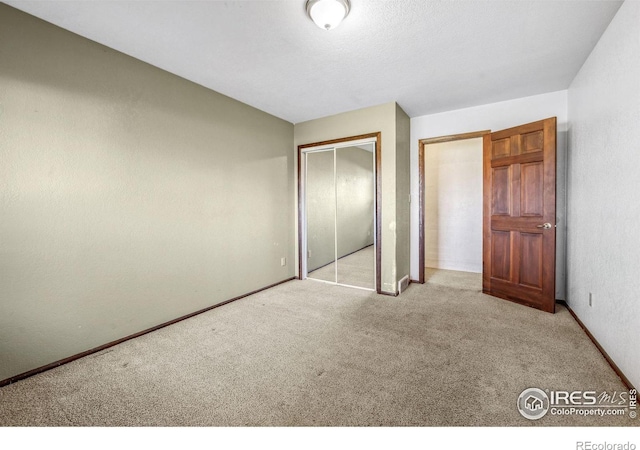 unfurnished bedroom with light colored carpet and a closet