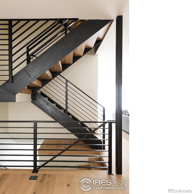 stairway with hardwood / wood-style floors