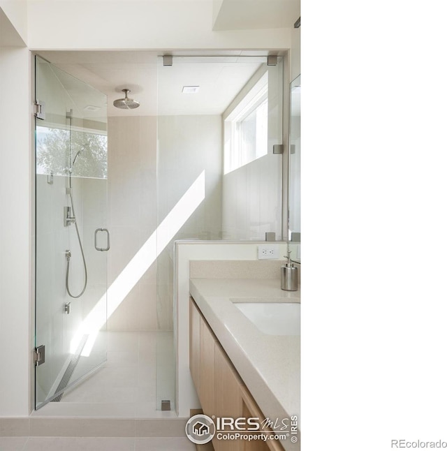 bathroom featuring vanity, tile patterned flooring, and an enclosed shower