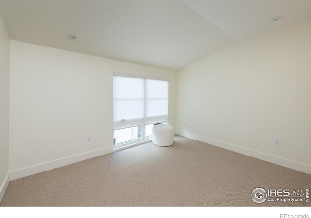 empty room with lofted ceiling and carpet floors