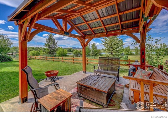 view of patio with a gazebo, a rural view, and fence