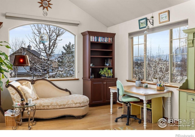 home office with vaulted ceiling and light wood-style flooring