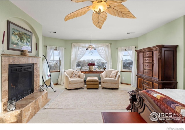 bedroom featuring a high end fireplace, light colored carpet, visible vents, and multiple windows