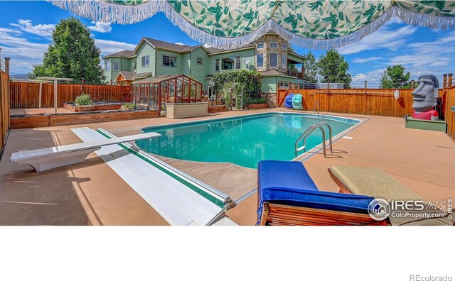 view of pool with a diving board, a patio, a fenced backyard, and a fenced in pool