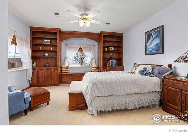 bedroom featuring light carpet, visible vents, and a ceiling fan