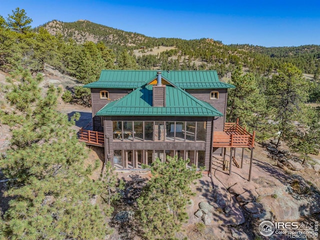 back of house featuring a sunroom and a mountain view