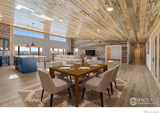 dining area with wood ceiling, light hardwood / wood-style flooring, wine cooler, and high vaulted ceiling