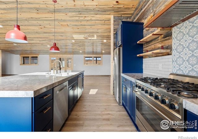 kitchen featuring appliances with stainless steel finishes, blue cabinets, pendant lighting, light wood-type flooring, and sink