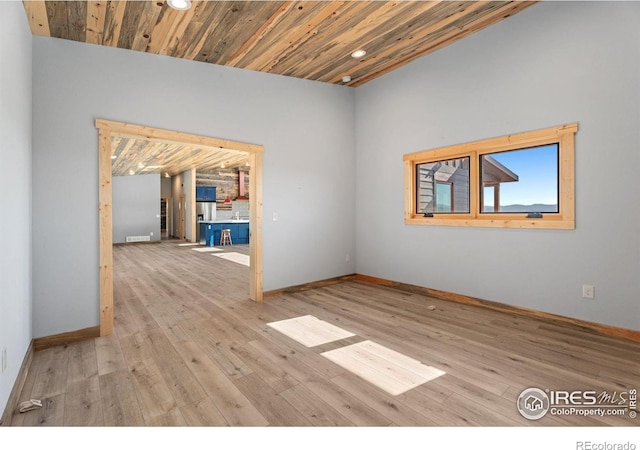 spare room featuring light hardwood / wood-style floors and wooden ceiling