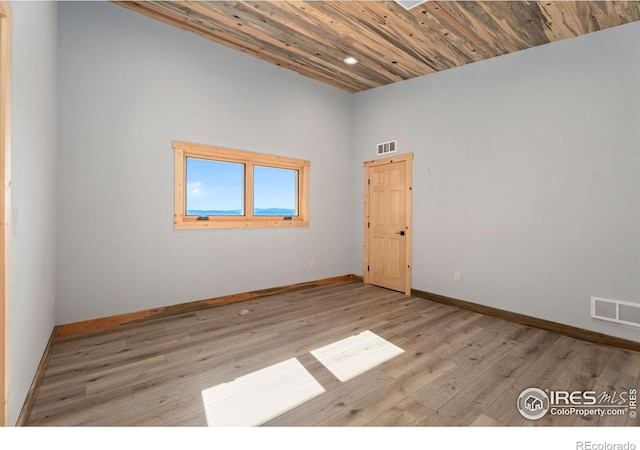 empty room featuring light hardwood / wood-style flooring and wooden ceiling