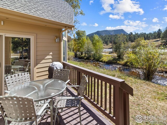 wooden terrace featuring outdoor dining area and a mountain view