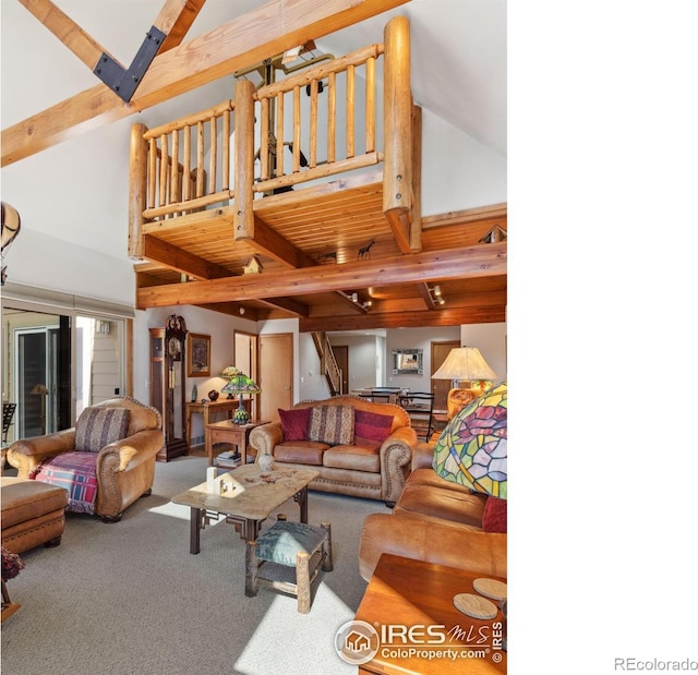 carpeted living room with stairs, beam ceiling, and a high ceiling