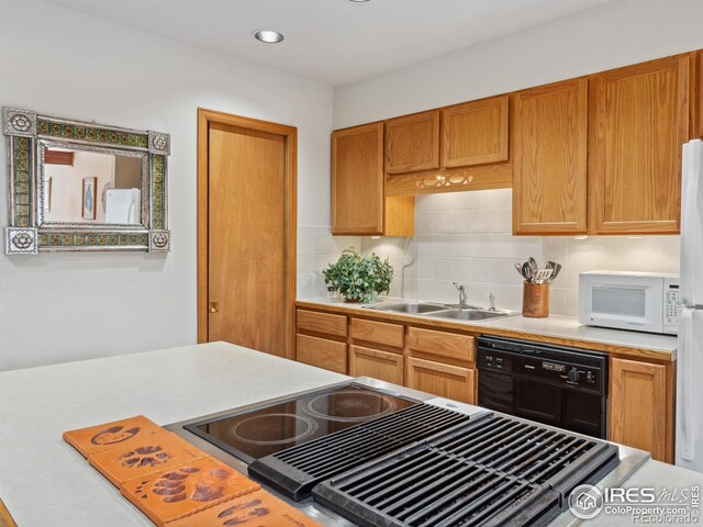 kitchen featuring dishwasher, light countertops, white microwave, and a sink